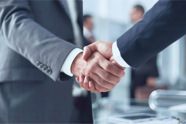 ビジネスパーソンが握手をしているクローズアップ。パートナーシップ、契約、合意、またはビジネスの成功を象徴する。