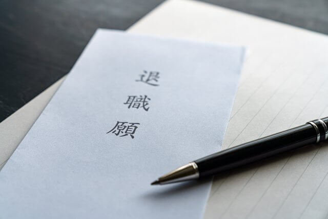 「退職願」と書かれた書類とペンのクローズアップ。仕事の退職、キャリアの変更、または転職に関連するイメージ。